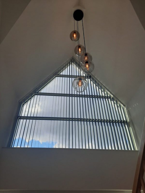 Verticale lamellen voor een schuin raam gemonteerd